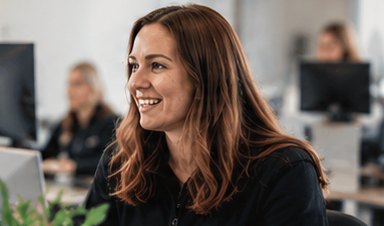 Office team member smiling at her desk